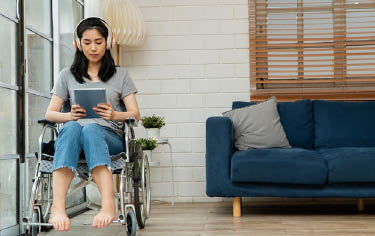 Women on wheelchair listen on ipad learning at home