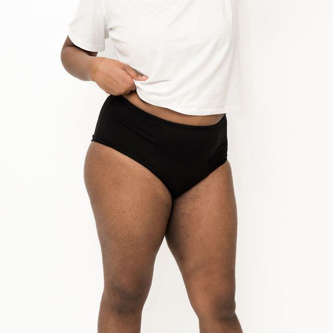 Person wearing black high-waisted Brolly underwear and a white t-shirt on a white background - Black